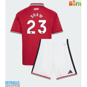 Billiga Manchester United Luke Shaw #23 Hemmatröja Barn 2026-27 Kortärmad (+ Korta byxor)